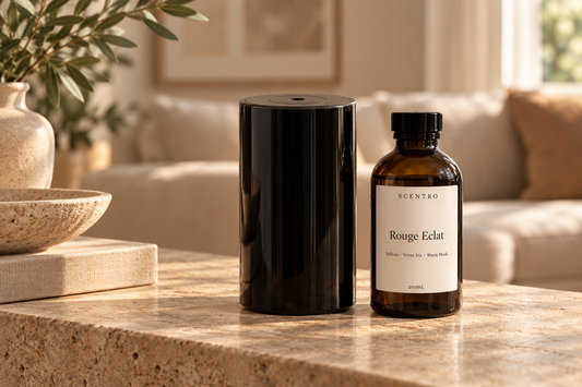 Black cold-air diffuser beside Scentro Home Rouge Éclat fragrance oil on a stone console.
